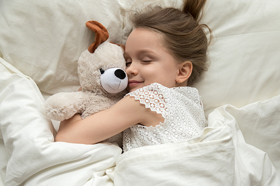 Bimba a letto che stringe un peluche